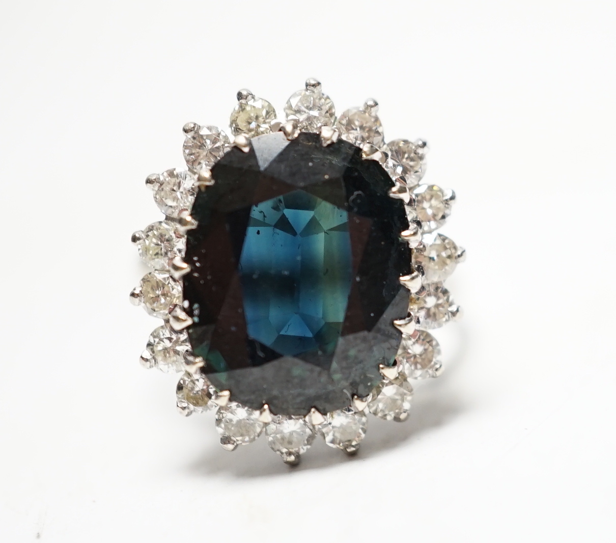 An 18ct, sapphire and diamond set oval cluster ring, size L, gross weight 5.7 grams.